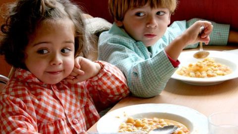 Dos ni&ntilde;os comen garbanzos