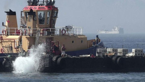 Remolcador de Gibraltar lanzando al mar bloques de hormig&oacute;n