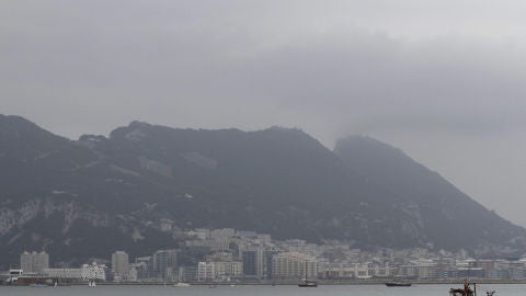 Un barco pesquero navega por la bahía de Algeciras con Gibraltar al fondo