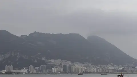 Un barco pesquero navega por la bahía de Algeciras con Gibraltar al fondo Un barco pesquero navega por la bahía de Algeciras con Gibraltar al fondo