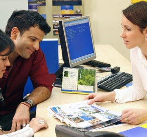Una pareja reserva sus vacaciones en una agencia de viajes Una pareja reserva sus vacaciones en una agencia de viajes