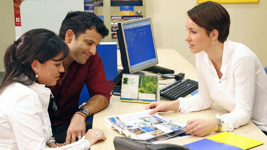 Una pareja reserva sus vacaciones en una agencia de viajes