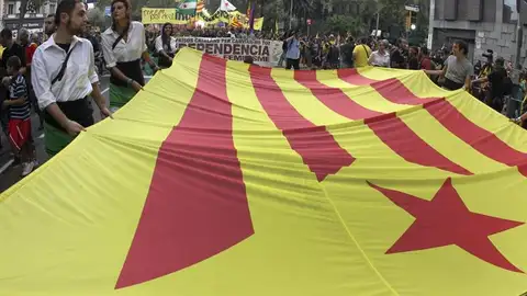 Varias personas sostienen una bandera "estelada" durante la manifestación de la Diada Varias personas sostienen una bandera "estelada" durante la manifestación de la Diada