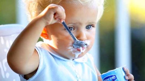 Ni&ntilde;a comiendo un yogur