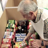 Un voluntario coloca alimentos en una caja