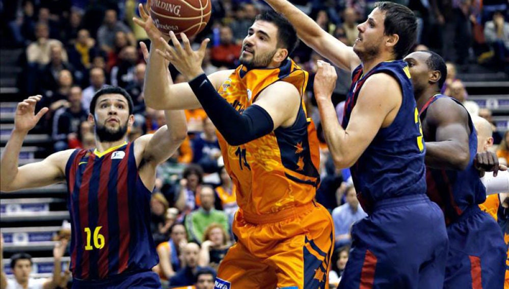 El ala pivot del Valencia Basket Bojan Dubljevic intenta superar la defensa del alero del Barcelona Bostjan Nachbar y del alero griego Kostas Papanikolau