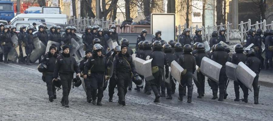 Decenas de policías antidisturbios vigilan la calle Grushevskogo, frente a una barricada de manifestantes en Kiev. Decenas de policías antidisturbios vigilan la calle Grushevskogo, frente a una barricada de manifestantes en Kiev.