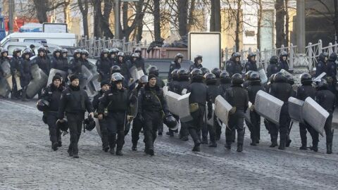 Decenas de polic&iacute;as antidisturbios vigilan la calle Grushevskogo, frente a una barricada de manifestantes en Kiev.