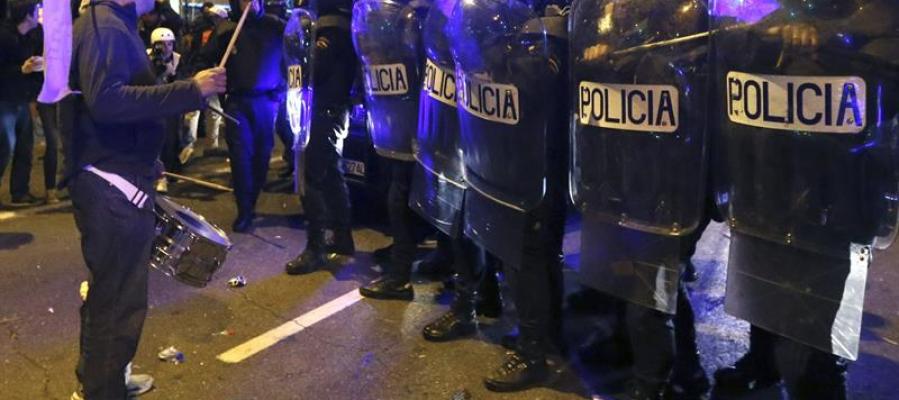 Un manifestante toca el tambor delante de los policías antidisturbios en la Plaza de Colón Un manifestante toca el tambor delante de los policías antidisturbios en la Plaza de Colón