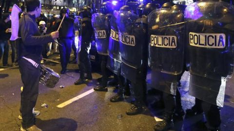Un manifestante toca el tambor delante de los polic&iacute;as antidisturbios en la Plaza de Col&oacute;n 