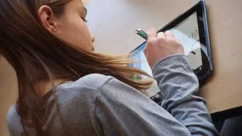 Una niña utiliza una tableta Una niña utiliza una tableta