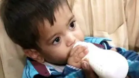 Mohammad Musa, de sólo nueve meses de edad, llegó a la audiencia judicial con su biberón Mohammad Musa, de sólo nueve meses de edad, llegó a la audiencia judicial con su biberón