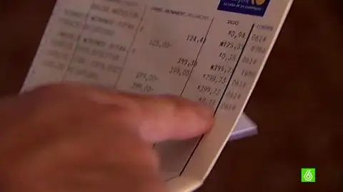 Un cliente consulta su libreta bancaria Un cliente consulta su libreta bancaria