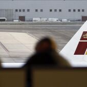 Dos pasajeros contemplan un avión de Iberia
