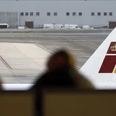 Dos pasajeros contemplan un avión de Iberia Dos pasajeros contemplan un avión de Iberia