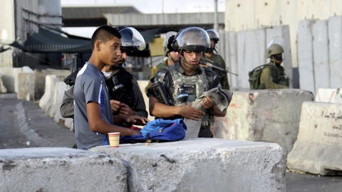 Varios soldados israel&iacute;es vigilan el puesto de control fronterizo de Qalandia