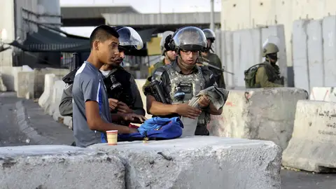 Varios soldados israelíes vigilan el puesto de control fronterizo de Qalandia Varios soldados israelíes vigilan el puesto de control fronterizo de Qalandia