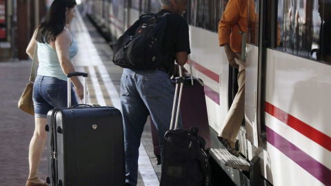 Varias personas montan a un tren en la estaci&oacute;n de Chamart&iacute;n, en Madrid