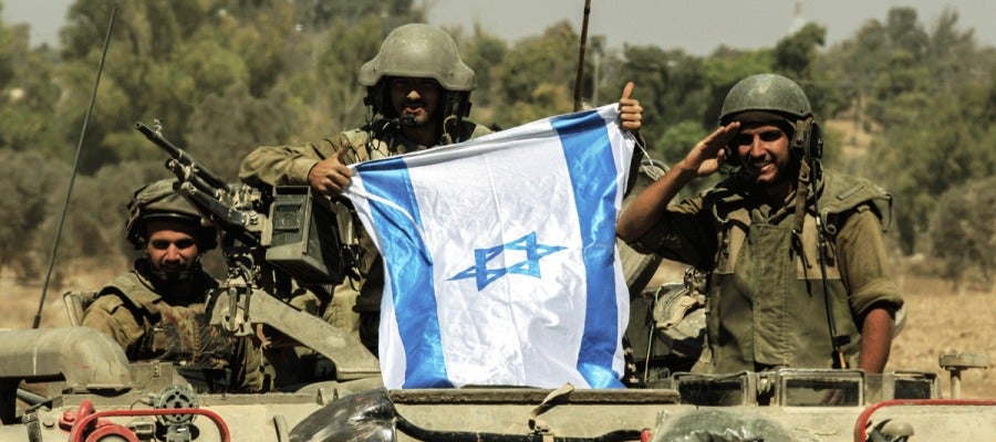 Soldados israelís portan una bandera de Israel sobre un tanque Soldados israelís portan una bandera de Israel sobre un tanque