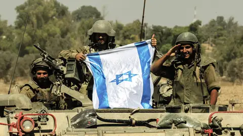 Soldados israelís portan una bandera de Israel sobre un tanque Soldados israelís portan una bandera de Israel sobre un tanque