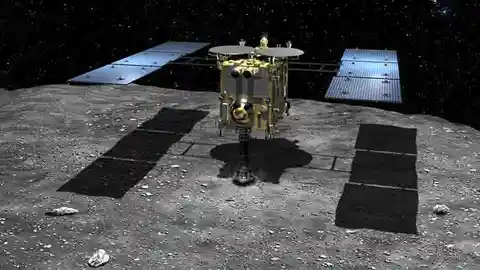Representación artística de la sonda Hayabusa 2 en el momento de tocar al asteroide (162173) 1999 JU3 para recoger muestras Representación artística de la sonda Hayabusa 2 en el momento de tocar al asteroide (162173) 1999 JU3 para recoger muestras