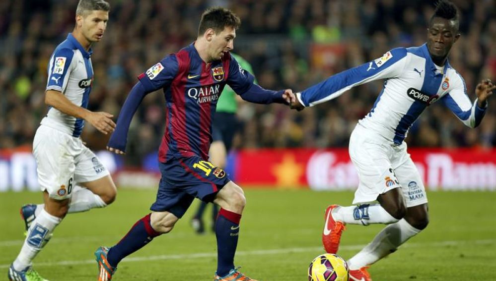 Messi conduce el balón junto a dos jugadores del Espanyol