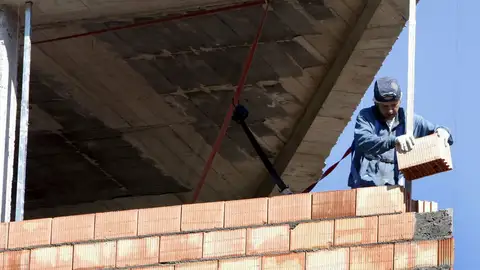 Un obrero construye una vivienda Un obrero construye una vivienda