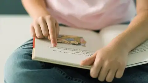 Una niña lee un libro de texto. Una niña lee un libro de texto.