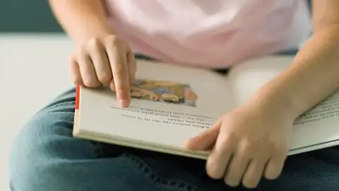 Una niña lee un libro de texto. Una niña lee un libro de texto.