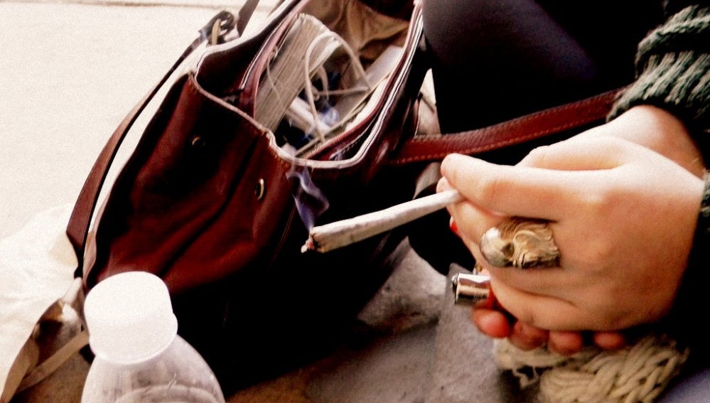 Una joven sostiene un cigarro 