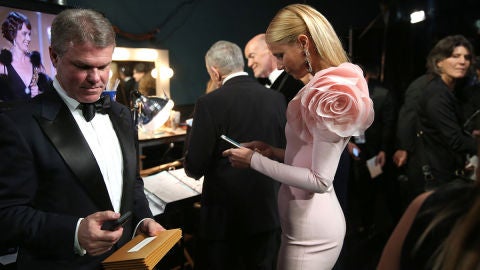 Gwyneth Paltrow revisa sus mensajes del m&oacute;vil entre bambalinas