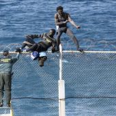 Imagen de archivo en la que dos inmigrantes intentan saltar la valla en Ceuta