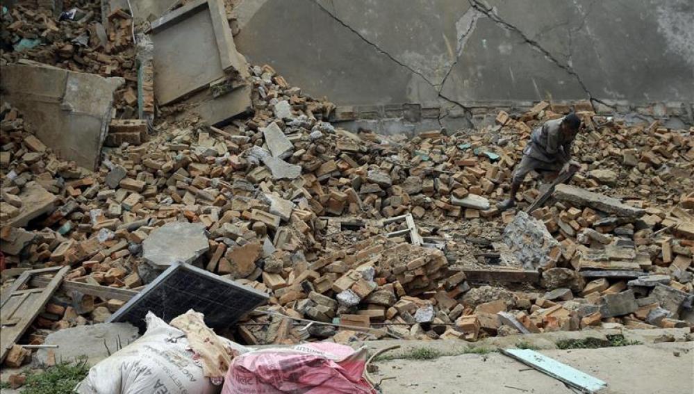 Un hombre busca entre los escombros de su hogar destruído tras el seísmo 