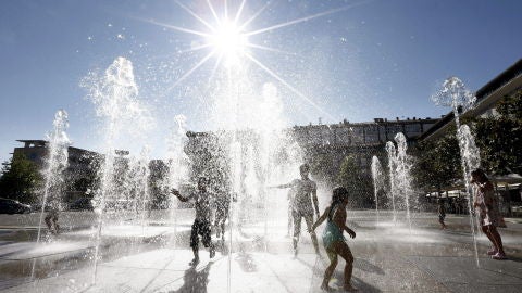 J&oacute;venes ba&ntilde;&aacute;ndose para soportar la ola de calor