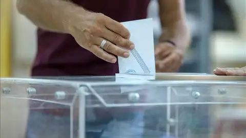 Un hombre deposita un voto en una urna Un hombre deposita un voto en una urna