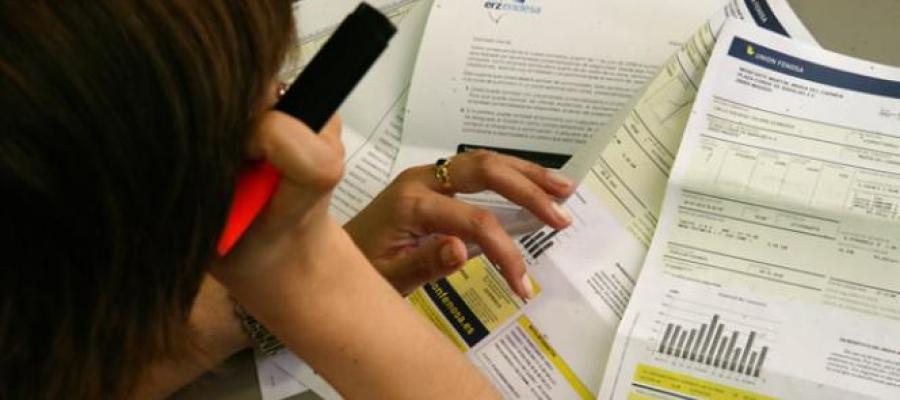 Una mujer estudia su factura de la luz Una mujer estudia su factura de la luz