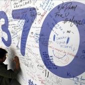 Un hombre escribiendo mensajes en honor a las víctimas del vuelo MH370 de Malaysia Airlines