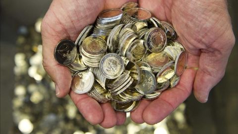 Un hombre sostiene varias monedas de euro