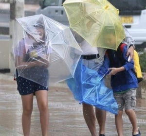 Varios viandantes luchan contra los fuertes vientos y la lluvia Varios viandantes luchan contra los fuertes vientos y la lluvia