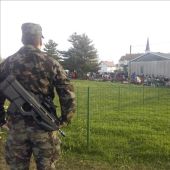 Un soldado vigila a un grupo de refugiados en el campamento provisional de Dobova, Eslovenia
