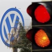 Logotipo de Volkswagen junto a un semáforo en rojo y naranja en Fallersleben, Alemania.