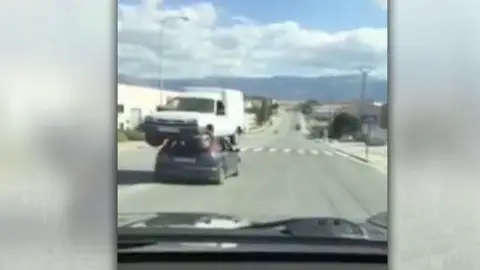 Imagen del coche circulando con una furgoneta encima Imagen del coche circulando con una furgoneta encima