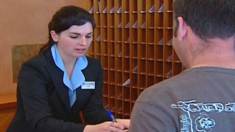 Una recepcionista atiende a un cliente