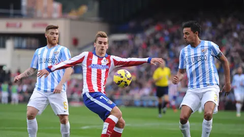 Griezmann controla el balón ante los defensores del Málaga Griezmann controla el balón ante los defensores del Málaga