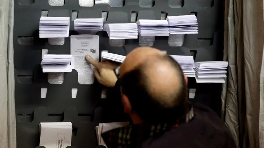 Un hombre elige las papeletas para las elecciones generales Un hombre elige las papeletas para las elecciones generales