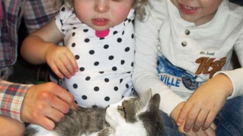 Ni&ntilde;a y gata con brazos amputados