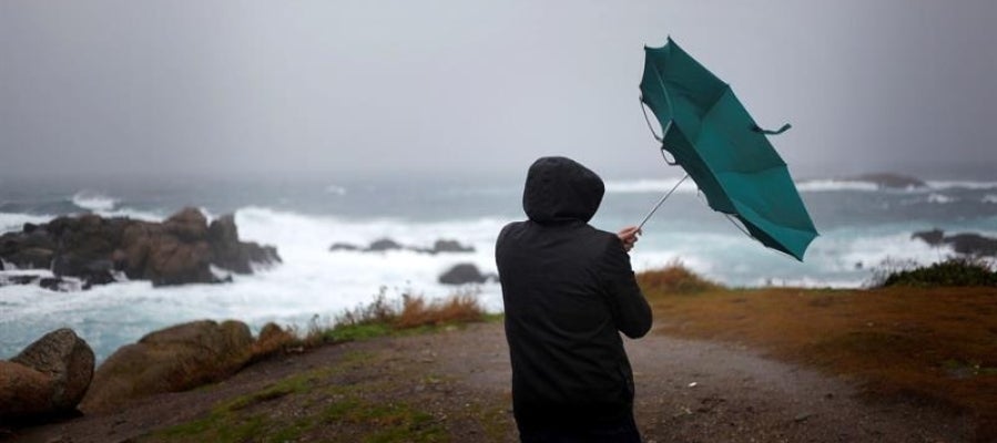 Un hombre ve como el viento le dobla el paraguas en A Coruña