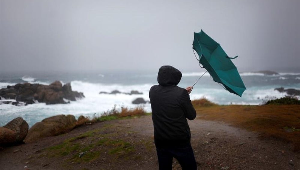 Un hombre ve como el viento le dobla el paraguas en A Coruña