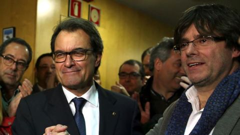 El presidente catal&aacute;n en funciones, Artur Mas (i), estrecha la mano del alcalde de Girona, Carles Puigdemont (d), a su llegada a la sede de CDC tras la rueda de prensa que ha ofrecido hoy en el Palau de la Generalitat en la que ha anunciado p&uacute;blicamente su renuncia a optar a la reelecci&oacute;n en beneficio de Puigdemont, quien ser&aacute; investido ma&ntilde;ana.