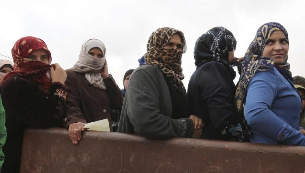 Un grupo de refugiadas sirias esperan ayuda en un campo